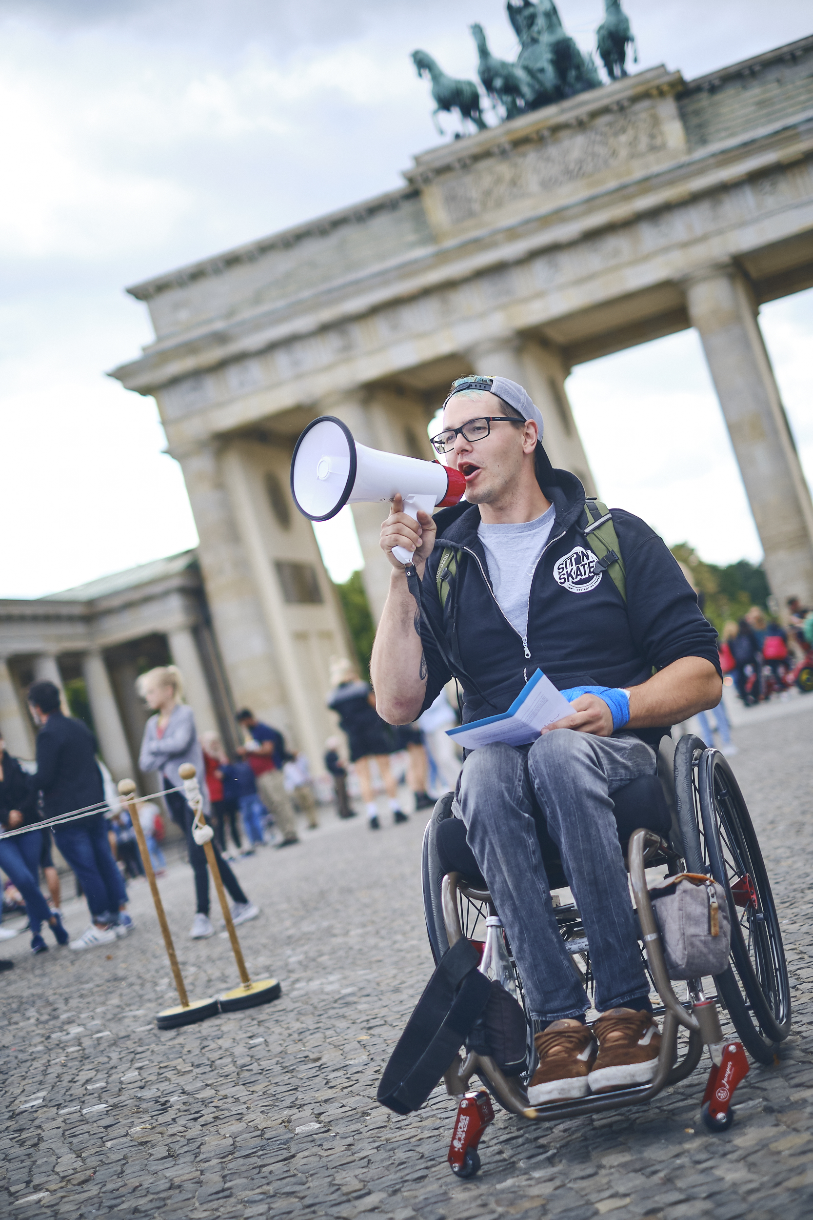 David steht vor dem Brandenburger Tor und brüllt durch ein Megafon!