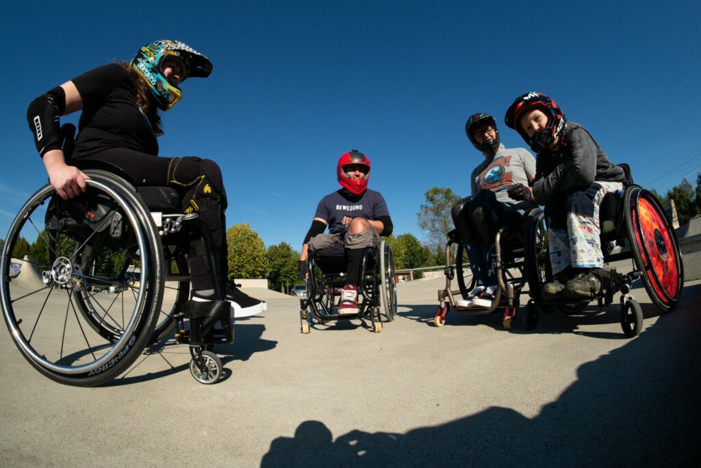 Eine Gruppe von Rollstuhlfahrern und Rollstuhlfahrerinnen im Skatepark.