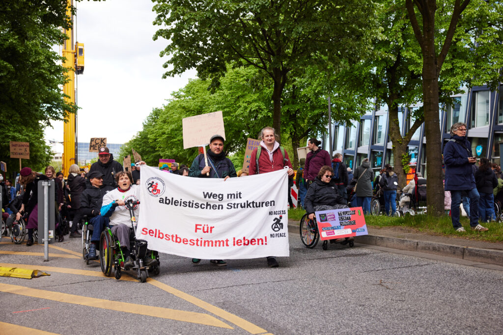 Transparent „Weg mit ableistischen Strukturen – Für selbstbestimmtes Leben!“ bei der Demo.