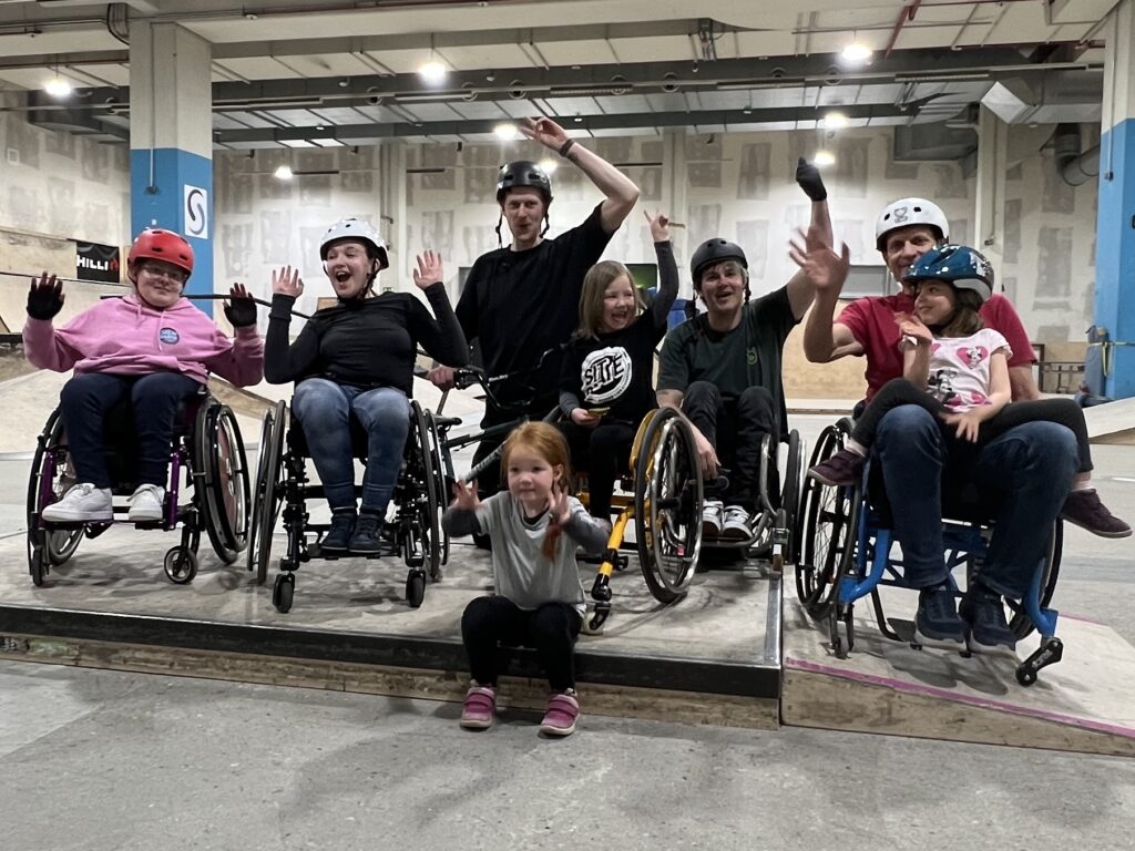 Gruppenbild von Menschen im Rollstuhl in einer Skatehalle.