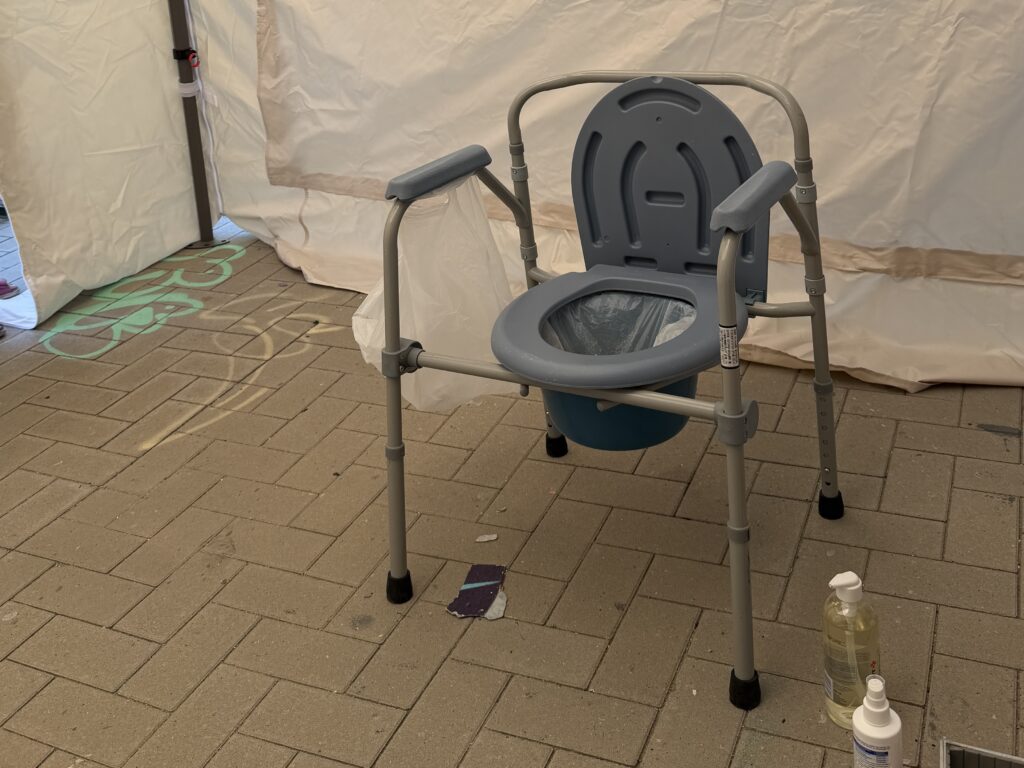 Campingtoilette in einem Pavillon.